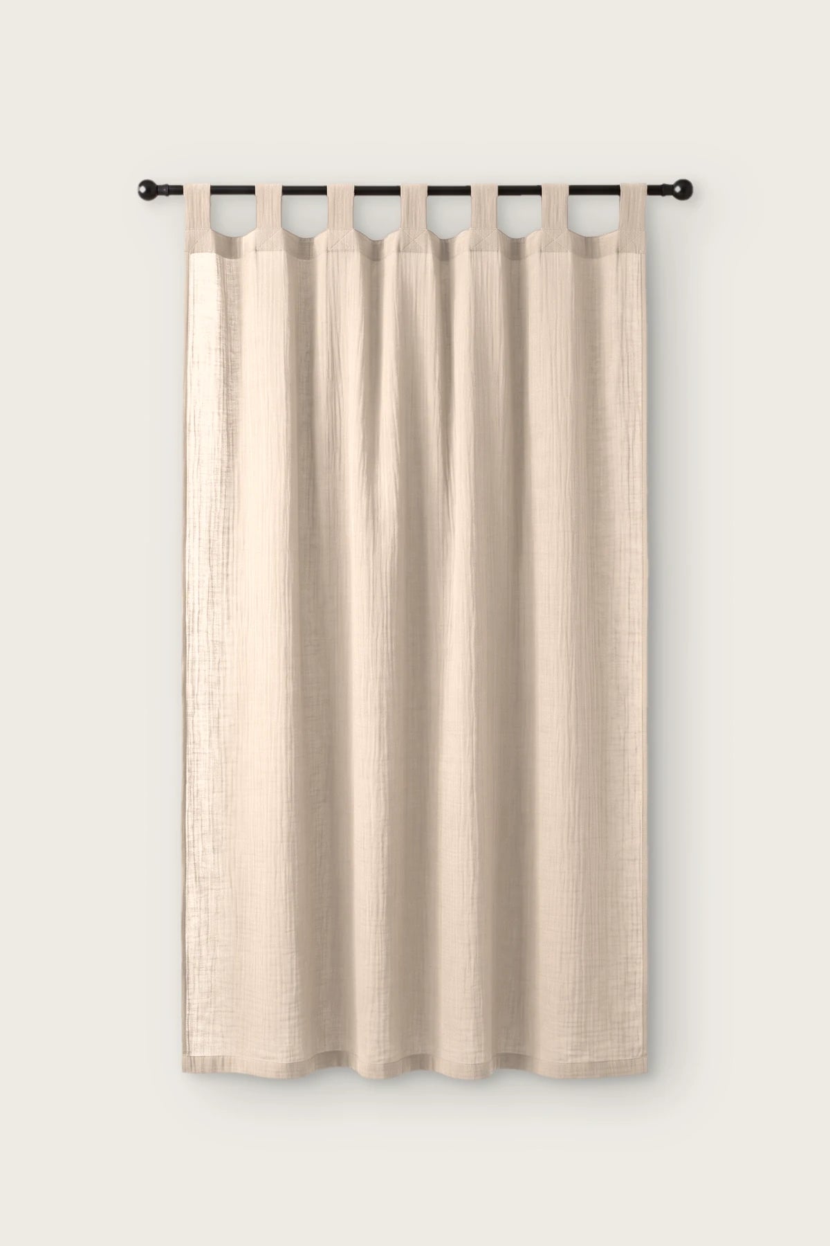2-layer muslin cotton curtain panel in beige, single tab top panel on a black rod, front view