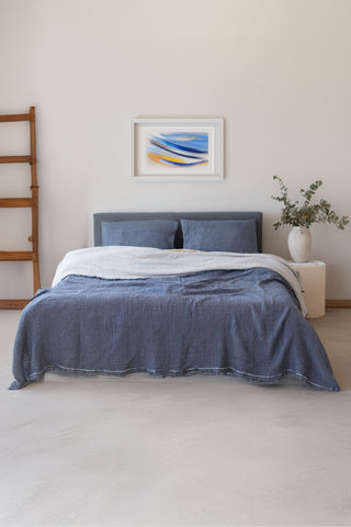 Indigo Blue muslin bedspread draped on bed showing handwoven 4-layer weave by Vivamaison