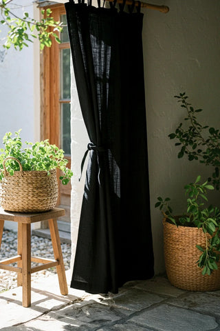 Black tab top panel with tieback, patio doorway scene. Handwoven 2-layer muslin cotton curtain, Denizli, OEKO-TEX. Vivamaison.
