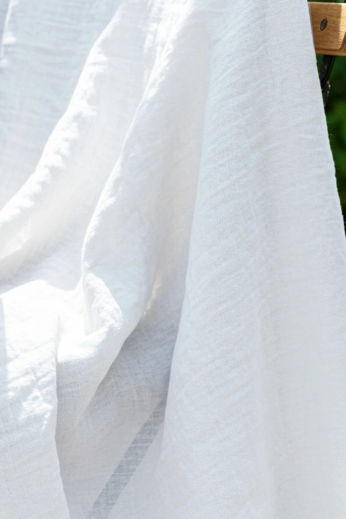 Sheer white gauze texture closeup outdoors. Handwoven 2-layer muslin cotton curtain, Denizli, OEKO-TEX. Vivamaison.