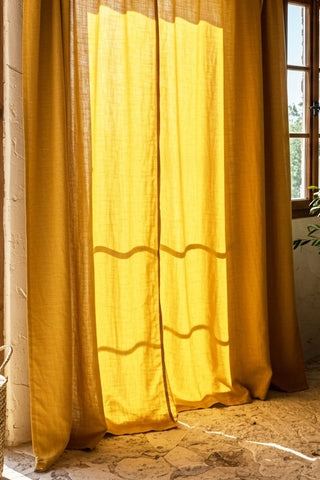Backlit mustard curtains at rustic indoor window. Handwoven 2-layer muslin cotton curtain, Denizli, OEKO-TEX. Vivamaison.