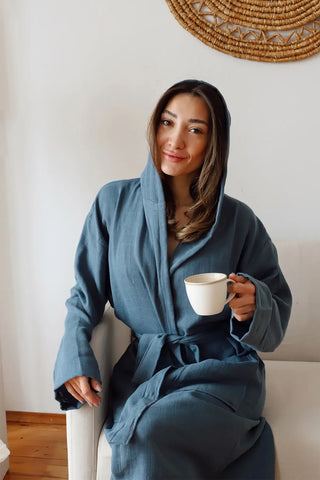 Indigo blue 2-layer muslin hooded bathrobe hood up seated closeup. Handwoven Turkish cotton Denizli, OEKO-TEX. Vivamaison.