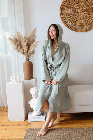 Sage green 2-layer muslin hooded bathrobe hood up seated. Handwoven Turkish cotton Denizli, OEKO-TEX. Vivamaison.
