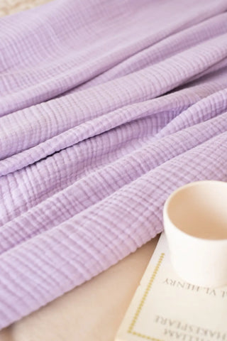 Lilac handwoven 4-layer muslin Turkish cotton bedspread folded flat lay. Long-staple Denizli, OEKO-TEX. Vivamaison.