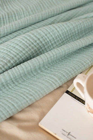 Sage Green handwoven 4-layer muslin Turkish cotton bedspread folded flat lay. Long-staple Denizli, OEKO-TEX. Vivamaison.