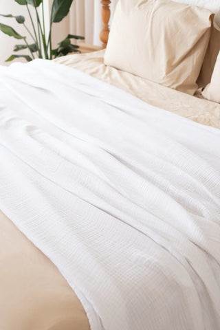 White handwoven 4-layer muslin Turkish cotton bedspread folded flat lay. Long-staple Denizli, OEKO-TEX. Vivamaison.