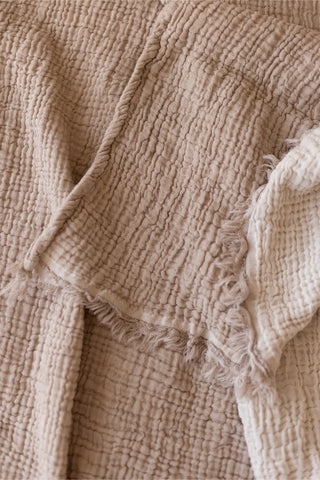 Brown handwoven 4-layer soft muslin fringed bedspread folded flat lay. Tasseled edges, Denizli, OEKO-TEX. Vivamaison.