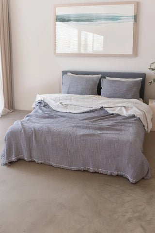 Grey handwoven 4-layer soft muslin fringed bedspread folded flat lay. Tasseled edges, Denizli, OEKO-TEX. Vivamaison.
