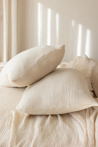 Natural handwoven 4-layer soft muslin fringed bedspread folded flat lay. Tasseled edges, Denizli, OEKO-TEX. Vivamaison.