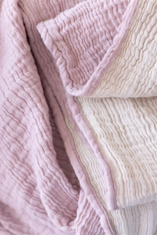 Pink handwoven 4-layer soft muslin fringed bedspread folded flat lay. Tasseled edges, Denizli, OEKO-TEX. Vivamaison.
