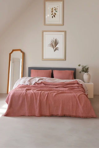 Terracotta handwoven 4-layer soft muslin fringed bedspread folded flat lay. Tasseled edges, Denizli, OEKO-TEX. Vivamaison.