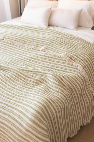 Green Striped handwoven 8-layer muslin Turkish cotton quilt close up. Hand-tied fringe Denizli, OEKO-TEX. Vivamaison.