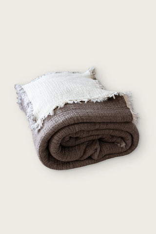 Handwoven 8-layer muslin Turkish cotton quilt in dark brown, rolled front view with hand-tied fringe