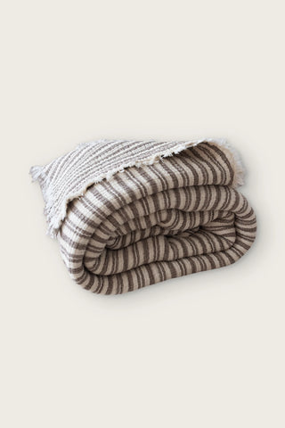 Handwoven 8-layer muslin Turkish cotton quilt in dark brown striped, rolled front view with hand-tied fringe