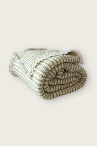 Handwoven 8-layer muslin Turkish cotton quilt in green striped, rolled front view with hand-tied fringe
