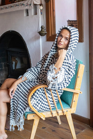 Anthracite white chickpea bathrobe hood up seated view. Handwoven Turkish cotton Denizli, OEKO-TEX. Vivamaison.