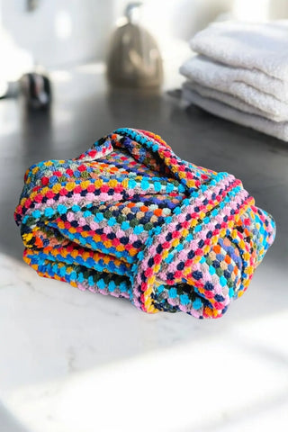 Rainbow chickpea bathrobe folded bathroom flat lay. Handwoven Turkish cotton Denizli, OEKO-TEX. Vivamaison.