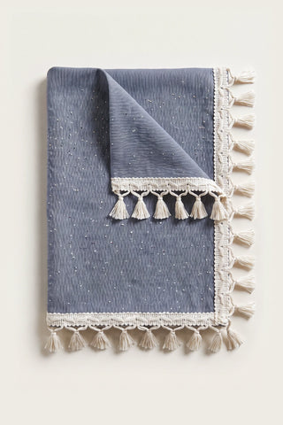 Handwoven Turkish cotton tassel tablecloth in navy blue, folded with corner turned back showing the tassel trim