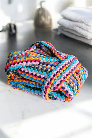 Rainbow mosaic bathrobe folded bathroom flat lay. Handwoven Turkish cotton Denizli, OEKO-TEX. Vivamaison.