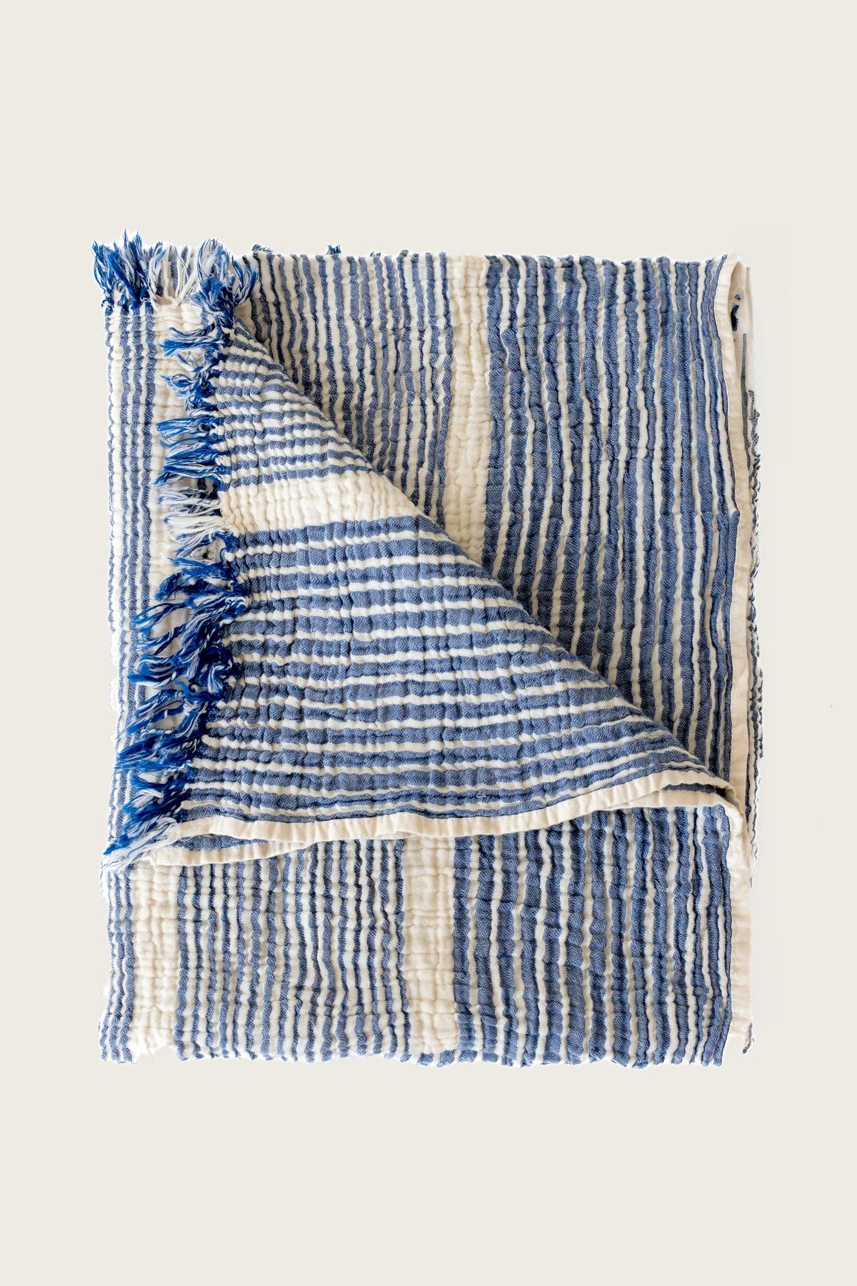 Blue striped peshtemal towel folded flat lay. Handwoven Turkish cotton Denizli, OEKO-TEX. Vivamaison.