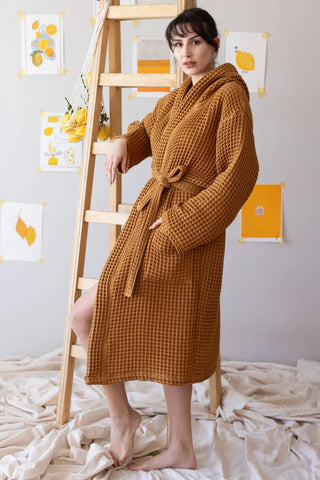 Caramel waffle hooded bathrobe side view on ladder. Handwoven Turkish cotton Denizli, OEKO-TEX. Vivamaison.