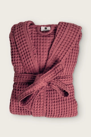 Handwoven waffle hooded bathrobe in dark red, folded front view with tied belt