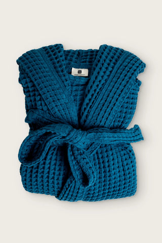 Handwoven waffle hooded bathrobe in indigo blue, folded front view with tied belt