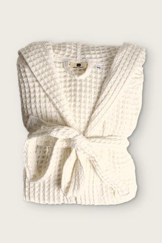 Handwoven waffle hooded bathrobe in natural, folded front view with tied belt
