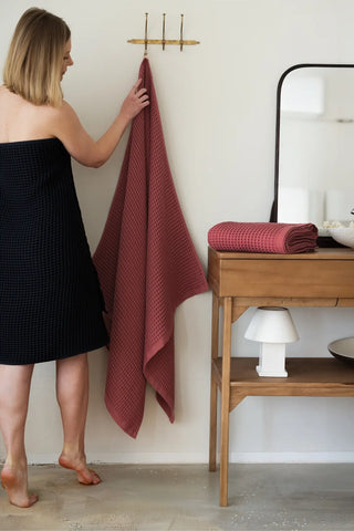 Dark Red handwoven Turkish cotton waffle weave towel lifestyle shoulder drop. Denizli, OEKO-TEX. Vivamaison.