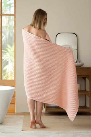 Pink handwoven Turkish cotton waffle weave towel lifestyle shoulder drop. Denizli, OEKO-TEX. Vivamaison.