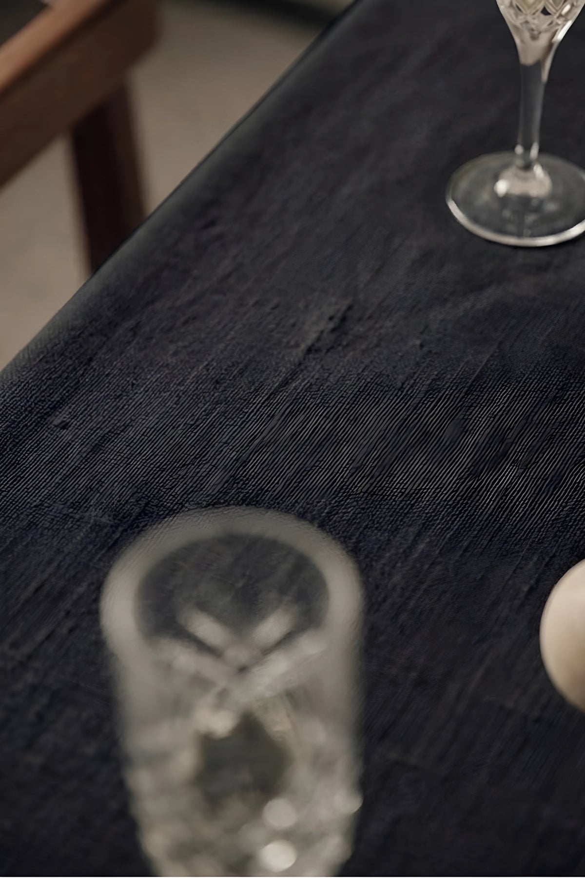 Black plain linen cotton blend tablecloth fabric texture close-up with a wine glass. 9 sizes, handmade in Denizli, OEKO-TEX. VivaMaison.