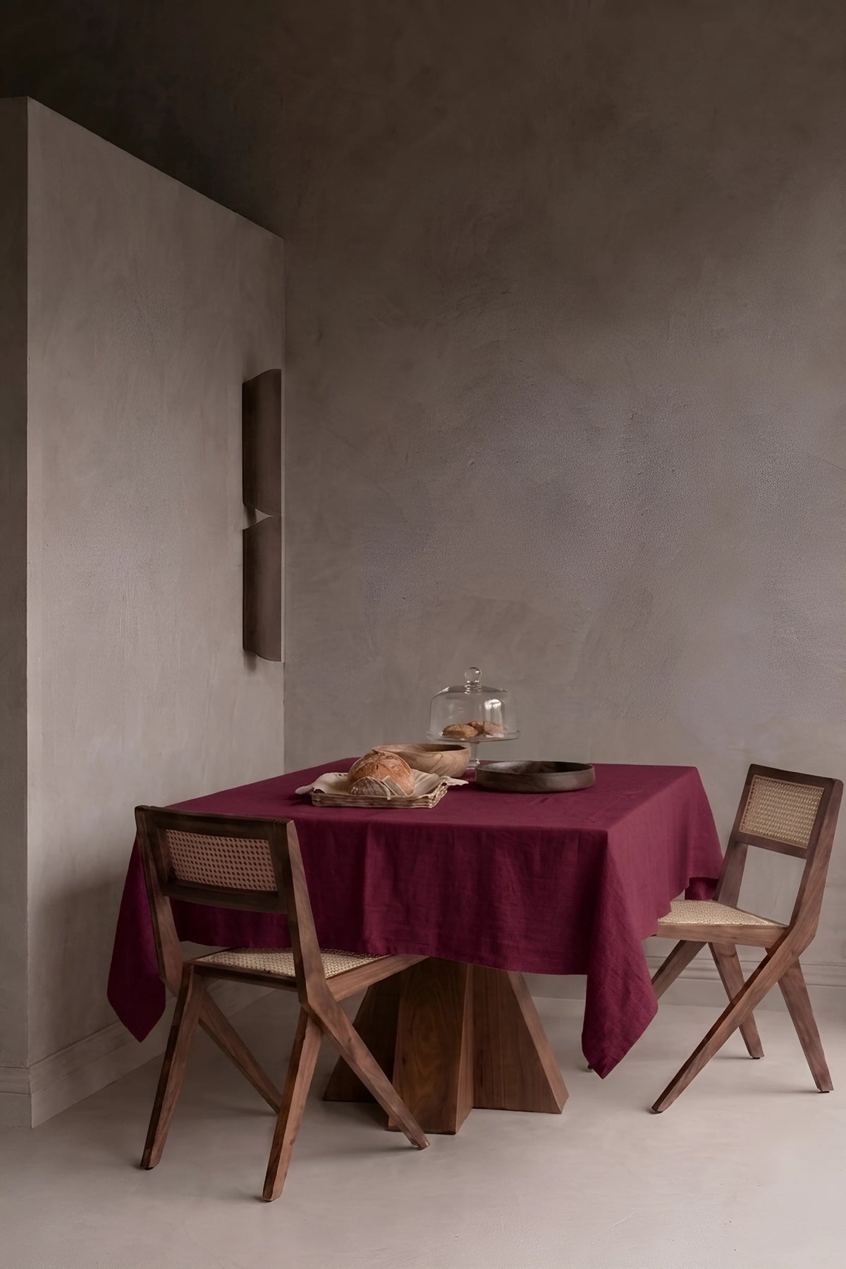 Burgundy plain linen cotton blend tablecloth on a dining table in a modern dining room with cane chairs. 9 sizes, handmade in Denizli, OEKO-TEX. VivaMaison.