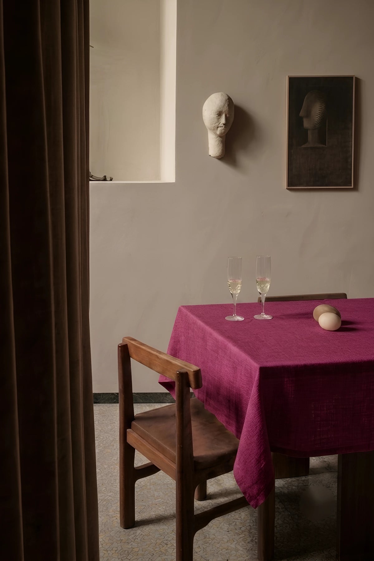 Burgundy plain linen cotton blend tablecloth on a dining table with champagne flutes, seen through a doorway. 9 sizes, handmade in Denizli, OEKO-TEX. VivaMaison.