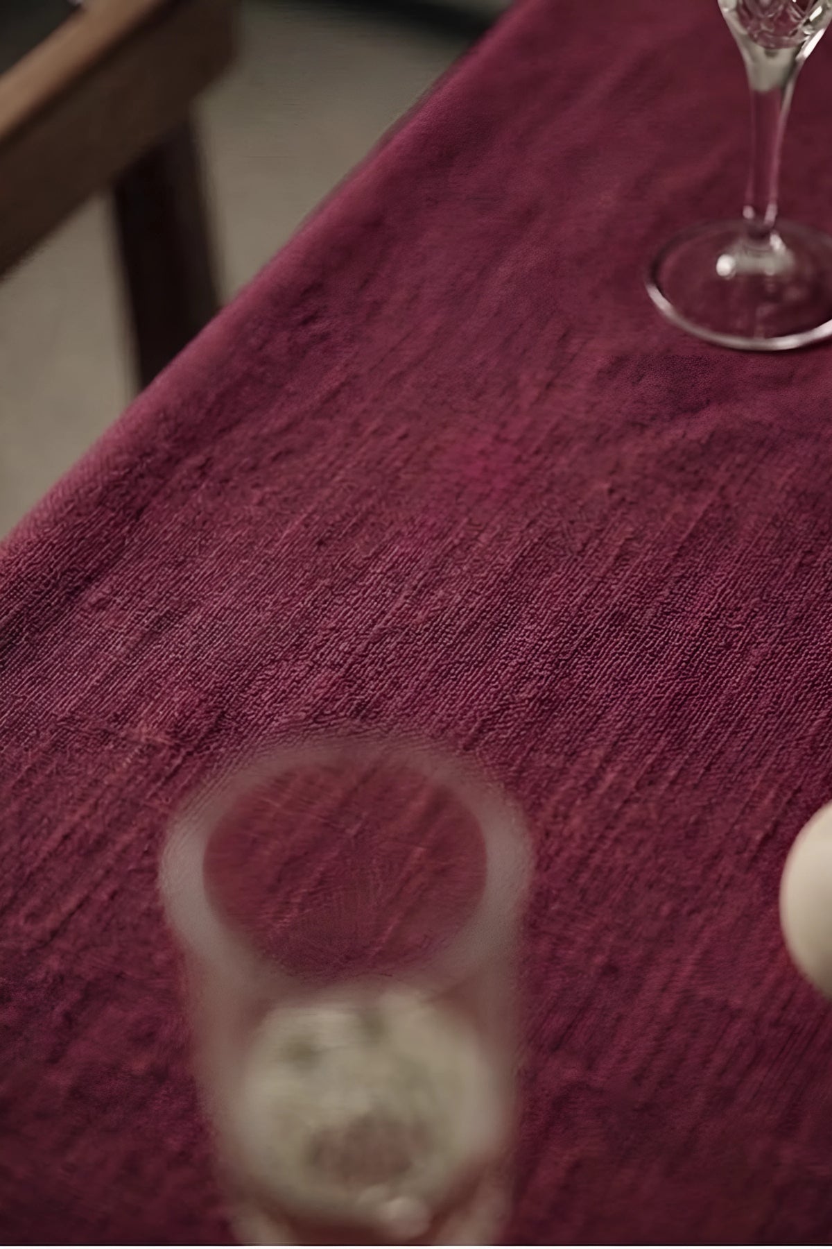 Burgundy plain linen cotton blend tablecloth fabric texture close-up with a wine glass. 9 sizes, handmade in Denizli, OEKO-TEX. VivaMaison.