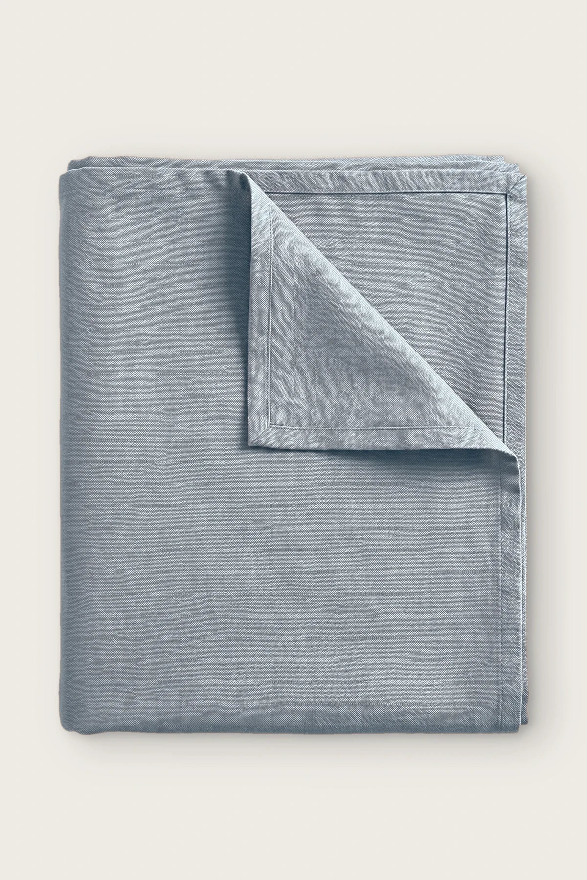 Plain linen cotton blend tablecloth in gray, folded with corner turned back