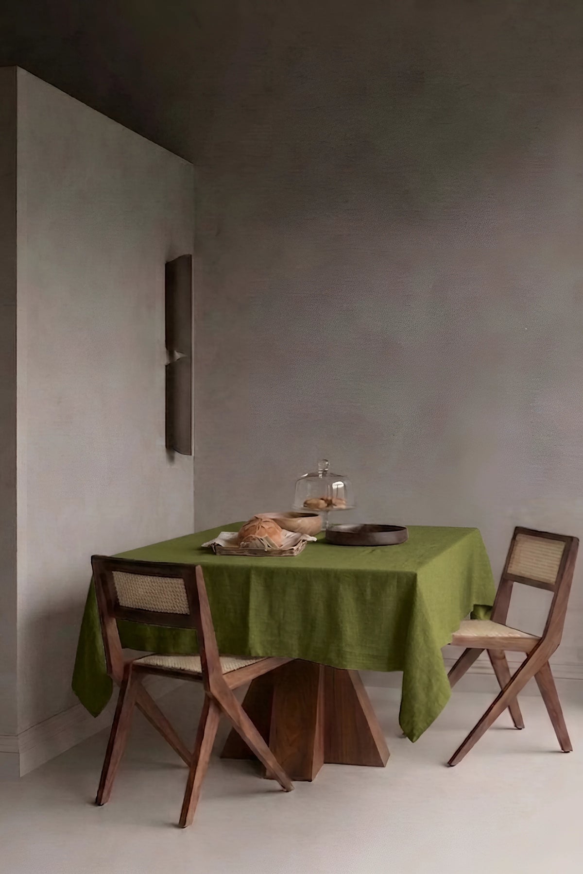 Olive Green plain linen cotton blend tablecloth on a dining table in a modern dining room with cane chairs. 9 sizes, handmade in Denizli, OEKO-TEX. VivaMaison.
