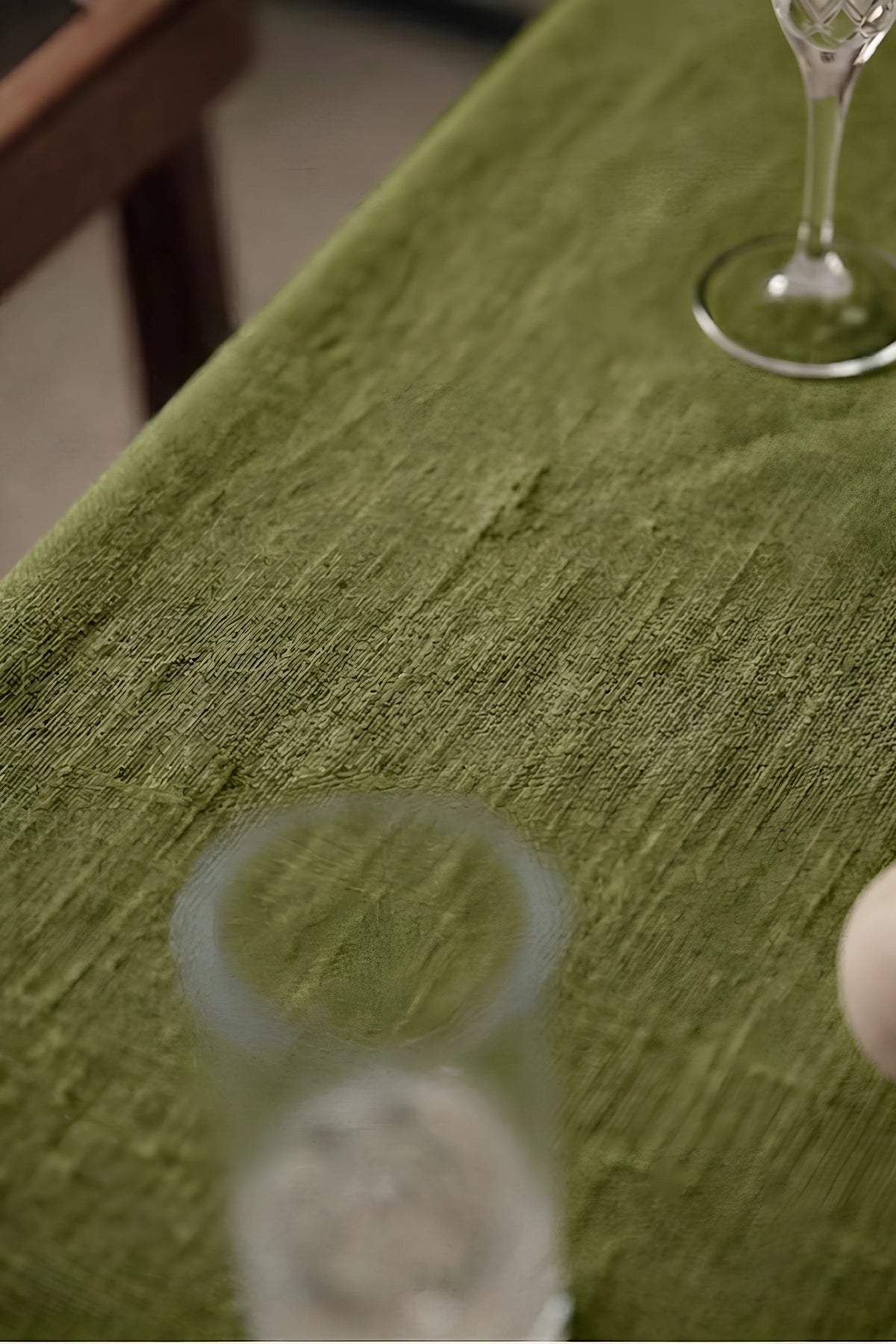 Olive Green plain linen cotton blend tablecloth fabric texture close-up with a wine glass. 9 sizes, handmade in Denizli, OEKO-TEX. VivaMaison.