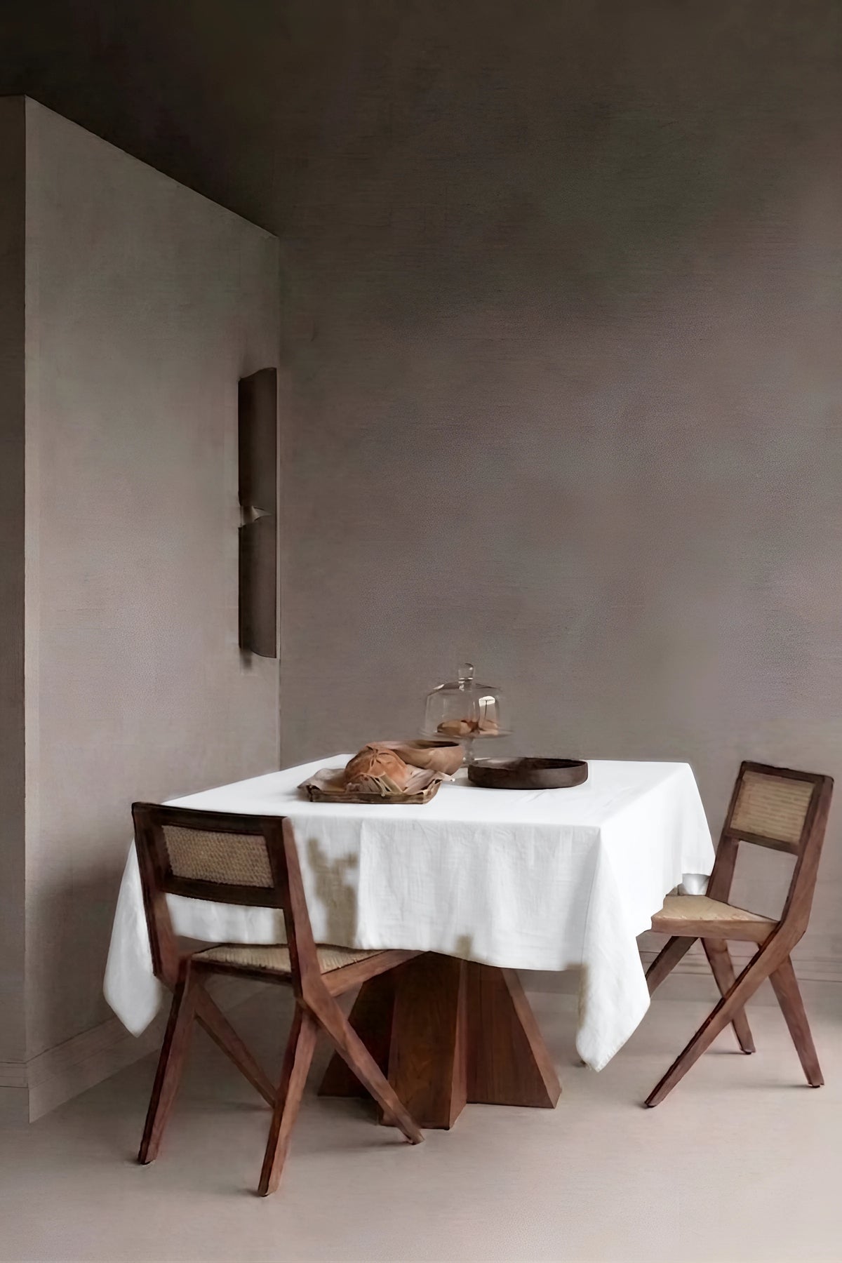 White plain linen cotton blend tablecloth on a dining table in a modern dining room with cane chairs. 9 sizes, handmade in Denizli, OEKO-TEX. VivaMaison.