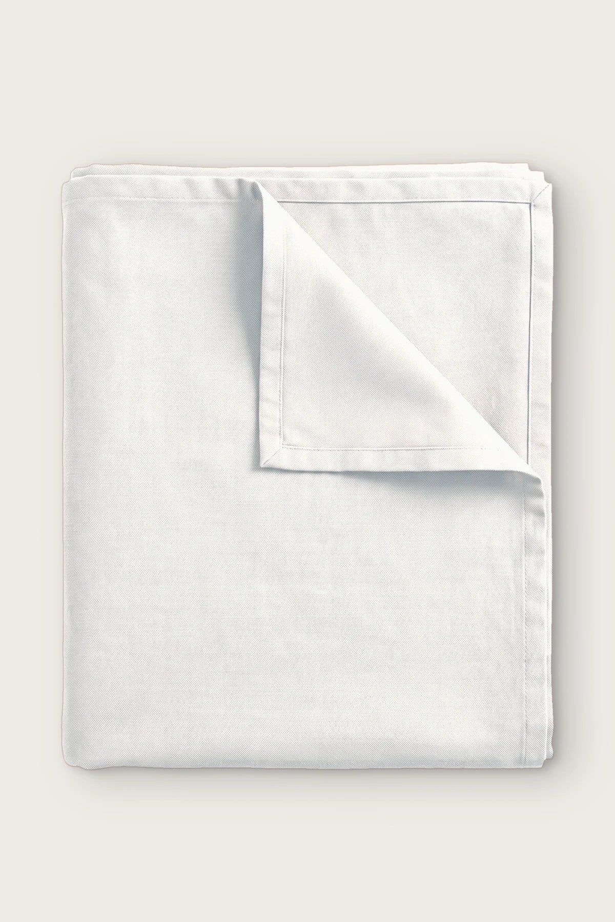 Plain linen cotton blend tablecloth in white, folded with corner turned back