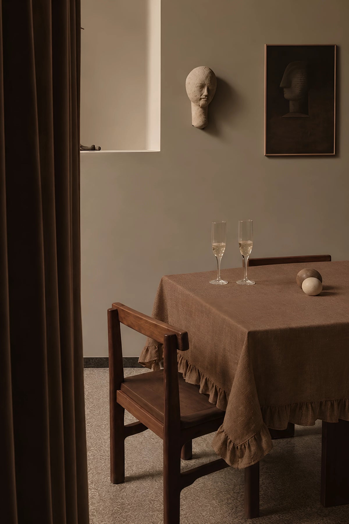 Brown ruffled linen cotton blend tablecloth on a dining table with champagne flutes, seen through a doorway. 9 sizes, handmade in Denizli, OEKO-TEX. VivaMaison.