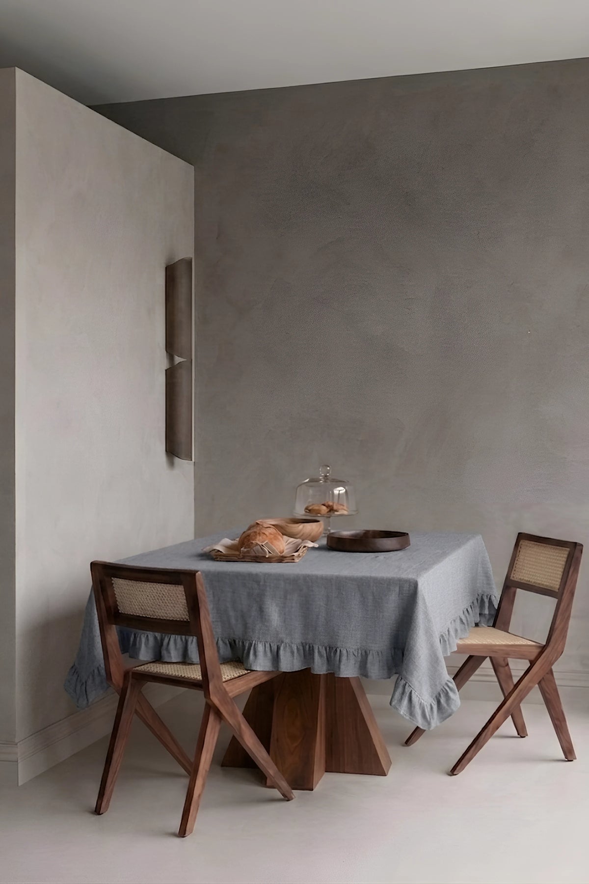 Gray ruffled linen cotton blend tablecloth on a dining table in a modern dining room with cane chairs. 9 sizes, handmade in Denizli, OEKO-TEX. VivaMaison.
