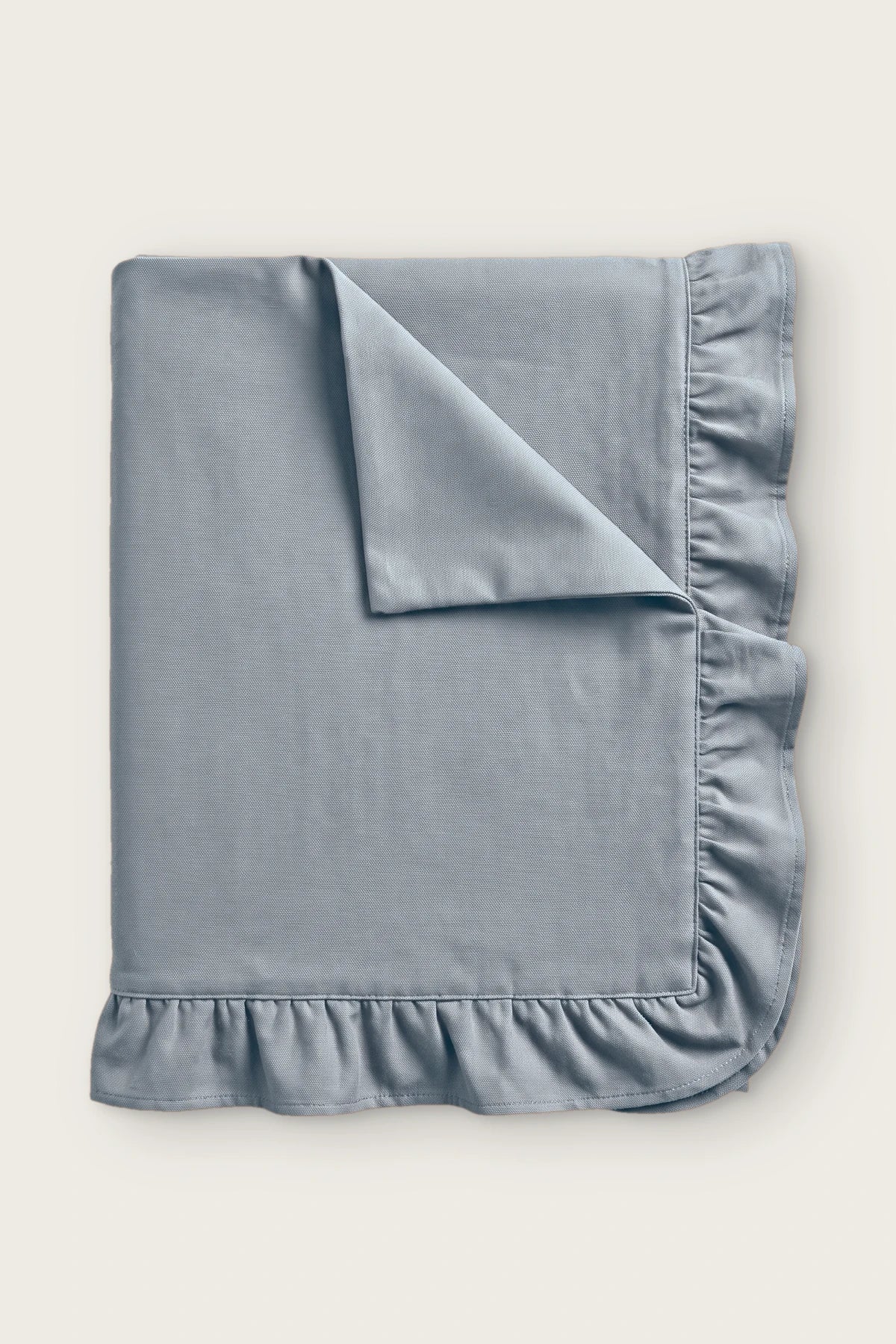 Ruffled linen cotton blend tablecloth in gray, folded with corner turned back