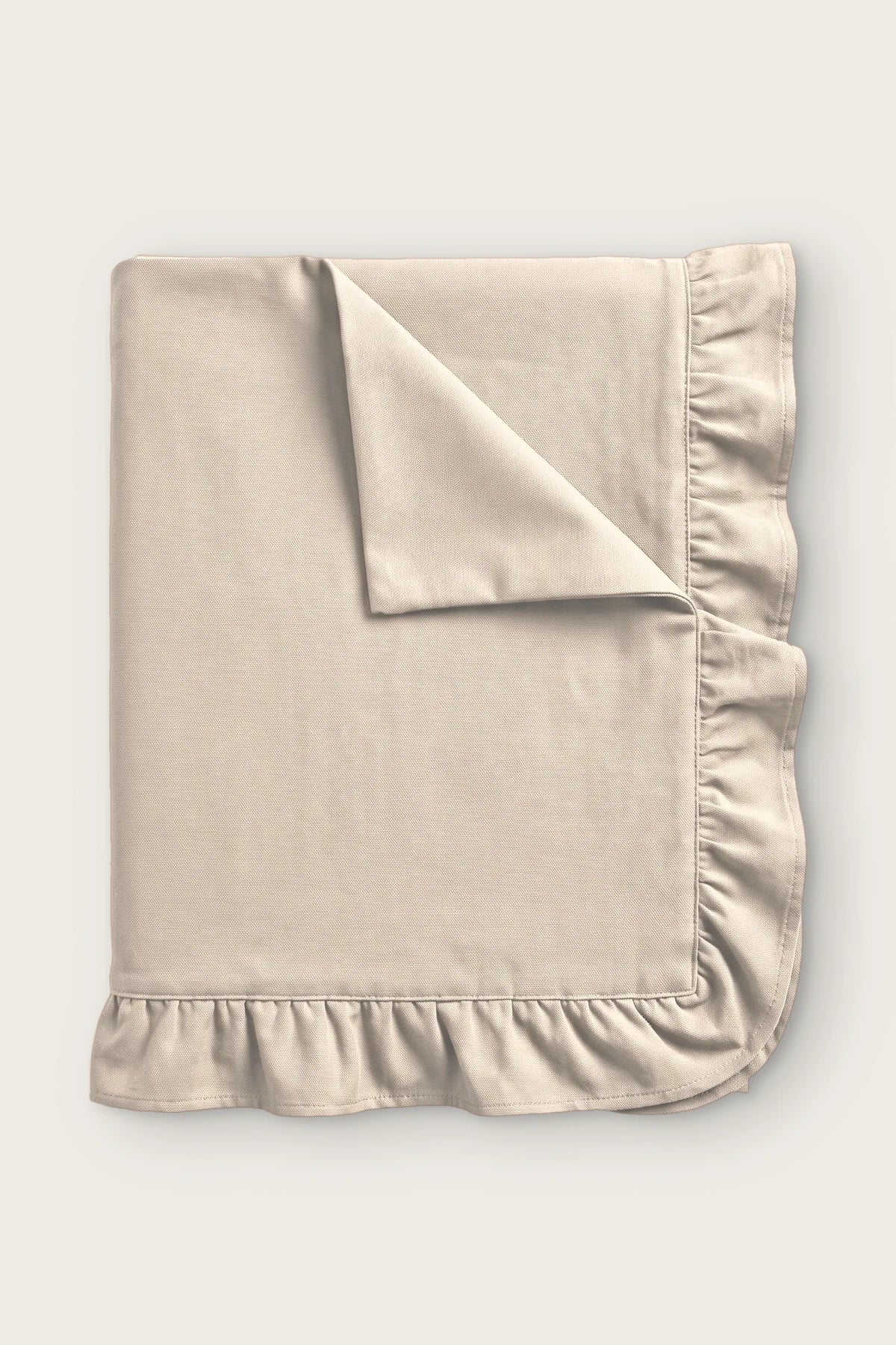 Ruffled linen cotton blend tablecloth in natural, folded with corner turned back