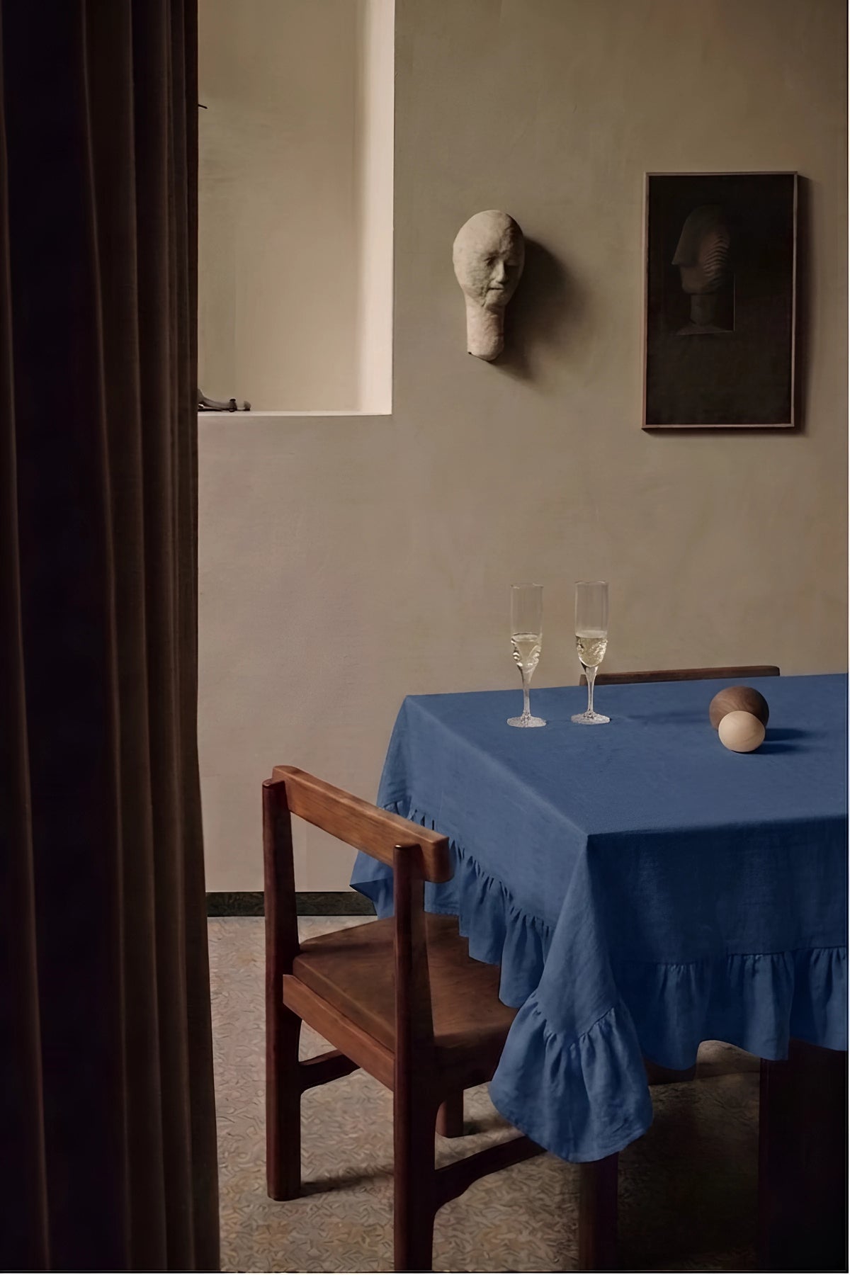 Navy ruffled linen cotton blend tablecloth on a dining table with champagne flutes, seen through a doorway. 9 sizes, handmade in Denizli, OEKO-TEX. VivaMaison.