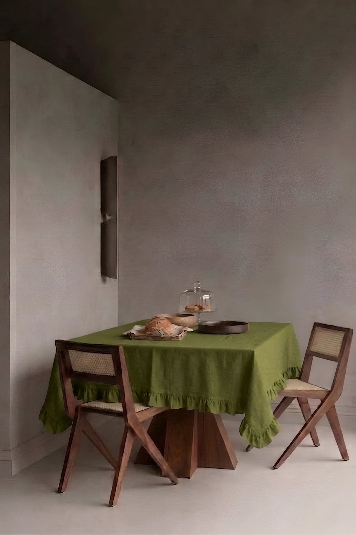 Olive Green ruffled linen cotton blend tablecloth on a dining table in a modern dining room with cane chairs. 9 sizes, handmade in Denizli, OEKO-TEX. VivaMaison.