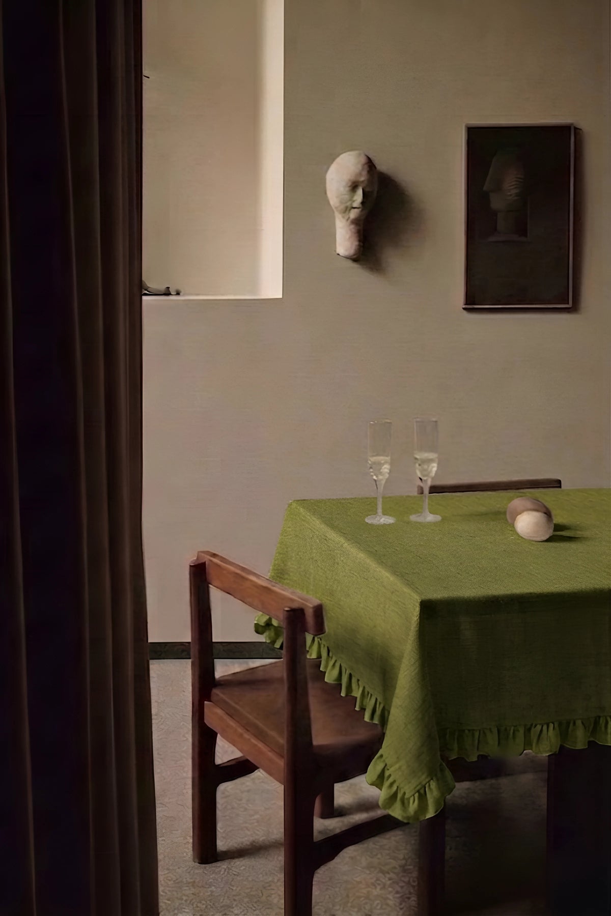 Olive Green ruffled linen cotton blend tablecloth on a dining table with champagne flutes, seen through a doorway. 9 sizes, handmade in Denizli, OEKO-TEX. VivaMaison.