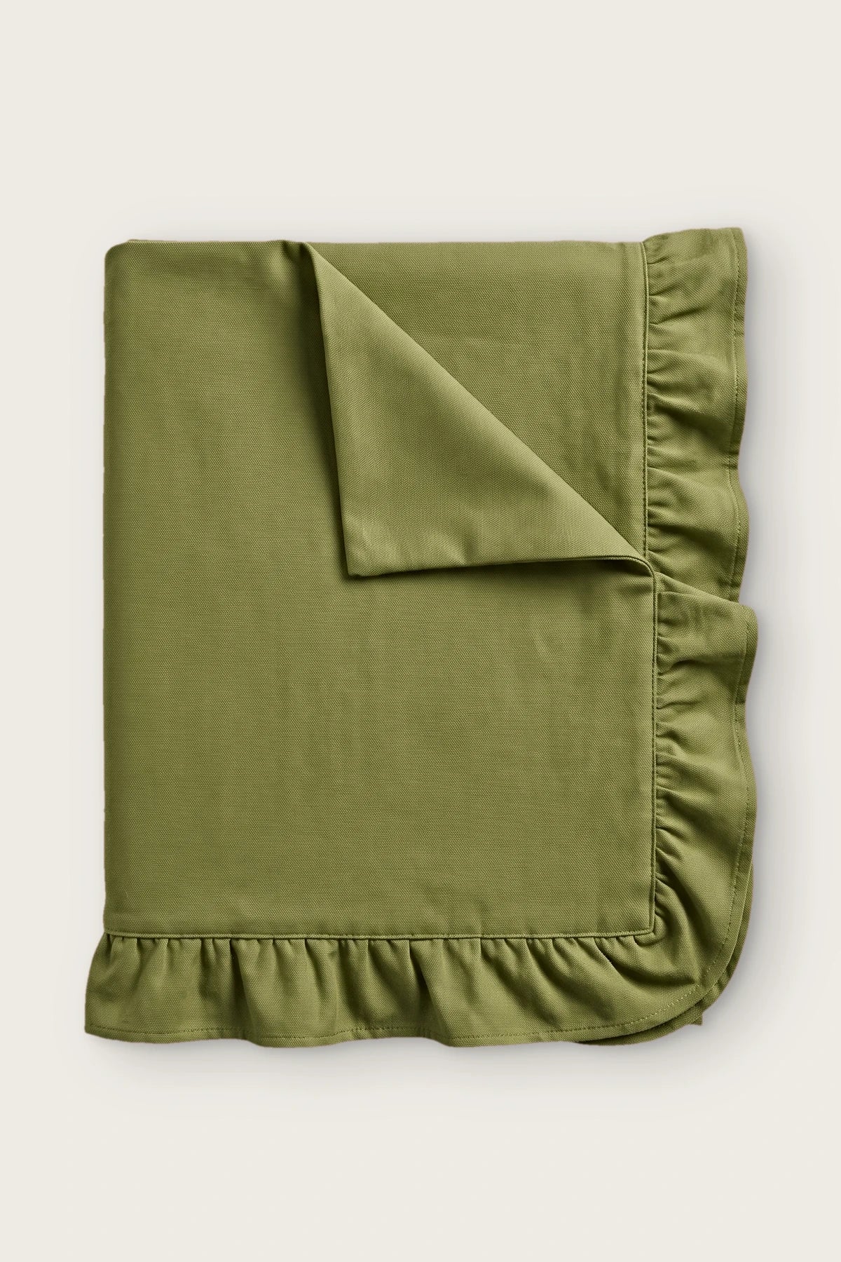 Ruffled linen cotton blend tablecloth in olive green, folded with corner turned back