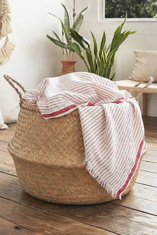 Muslin striped Turkish cotton beach towel peshtemal with red stripes styled in a seagrass basket - VivaMaison