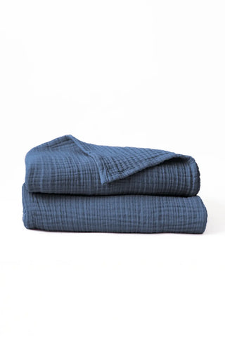 Folded indigo blue handwoven muslin towels showing the breathable 4-layer cotton texture by VivaMaison