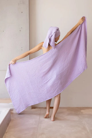 Folded lilac handwoven muslin towels showing the breathable 4-layer cotton texture by VivaMaison